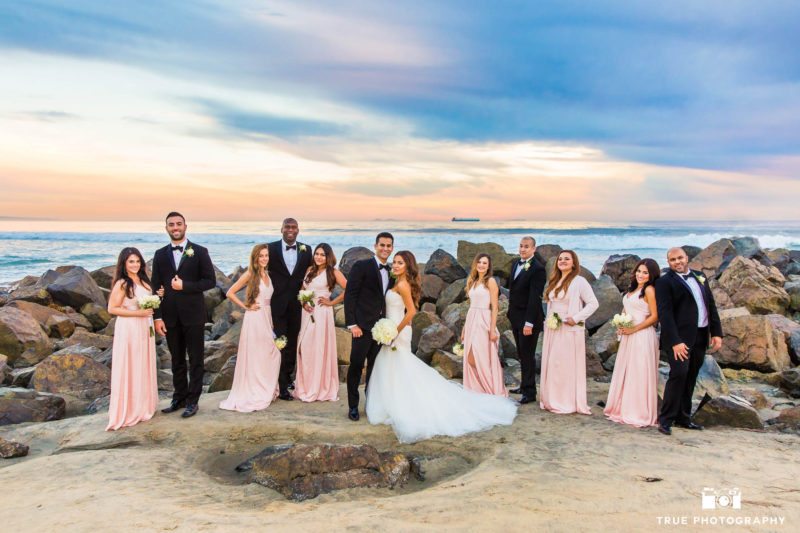 Bridal party with wedding couple on rocks at Coronado Beach