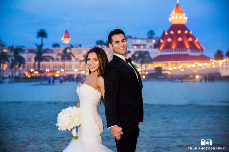Bride and Groom hold hands in front of Hotel Del Coronado