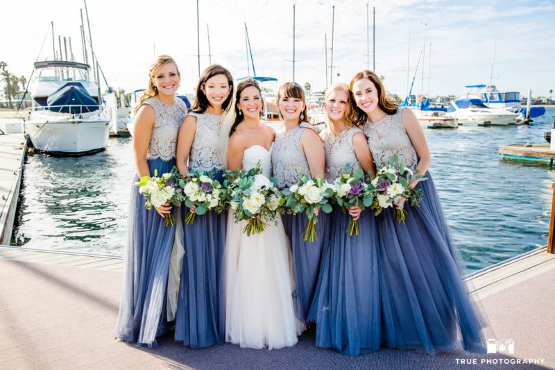 Bride with bridesmaids in 2-piece dresses at marina