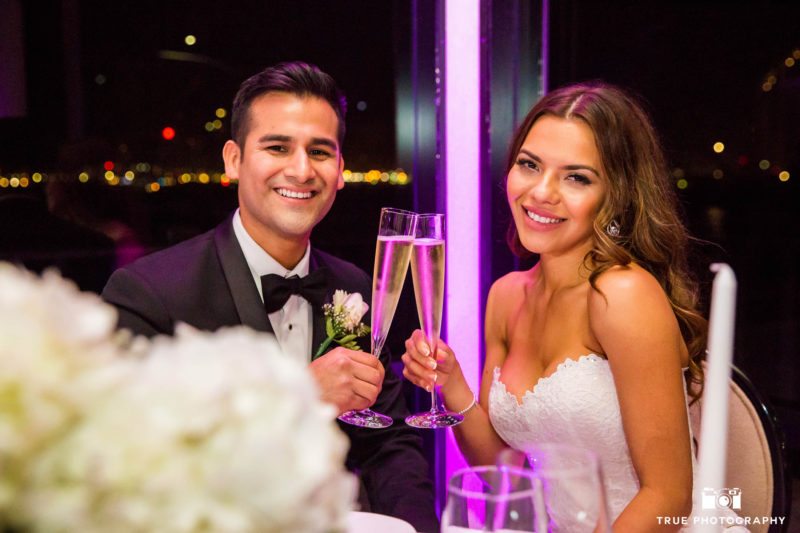 Bride and Groom smile at camera for champagne toast during reception