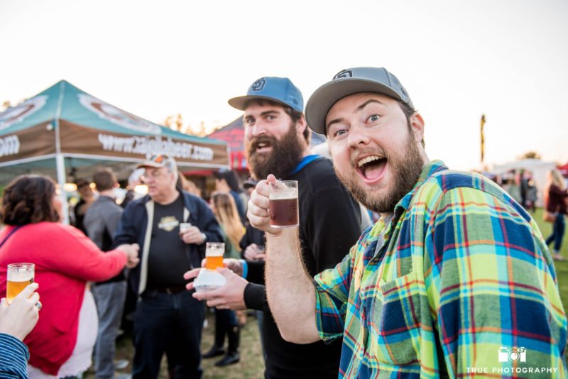 Eventgoers hold up beer tasters at Best Coast Beer Fest