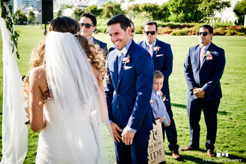 Groom laughs with tears of joy when he sees bride