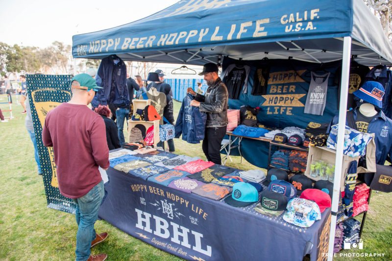 Event goers browse merchandise at Hoppy Beer Hoppy Life booth at Best Coast Beer Fest in Embarcadero Park