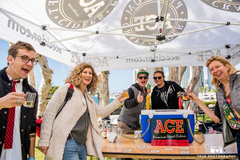 Event goers pose for group photo at ACE Cider Booth during Best Coast Beer Fest