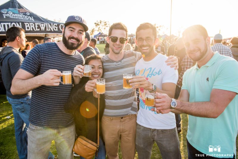 Friends hug and toast with beer tasters during cancer charity event, Best Coast Beer Fest