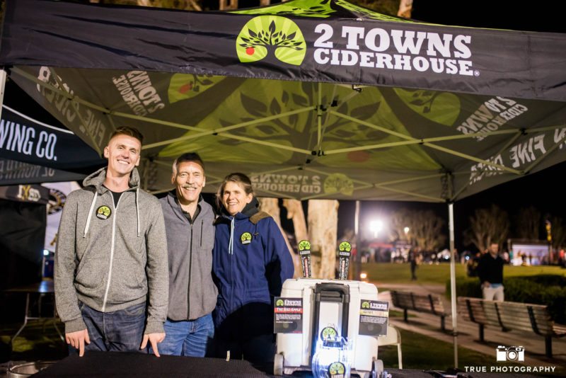 2 Towns Ciderhouse brewers pose for photo at booth during Best Coast Beer Fest