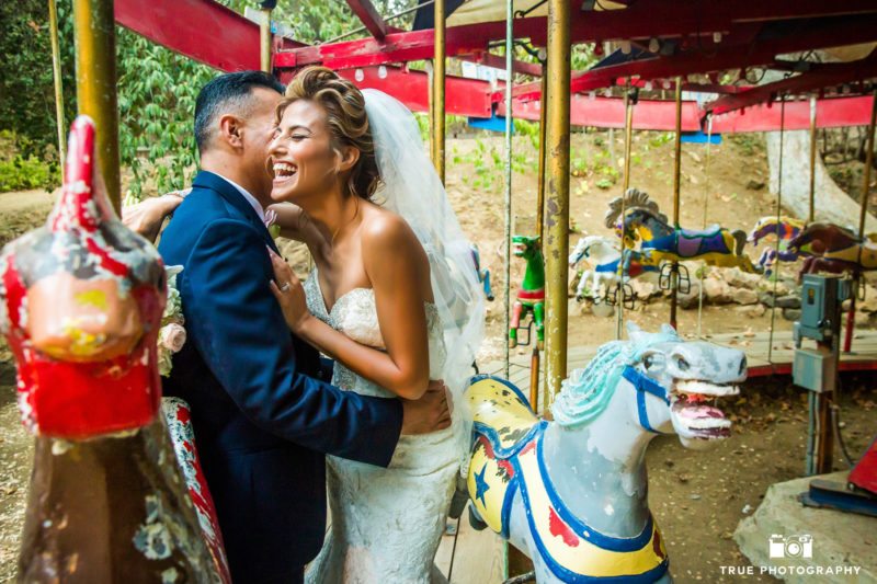 Bride and Groom embrace while laughing in carousel