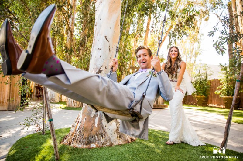 Bride and Groom have fun on swing before wedding ceremony