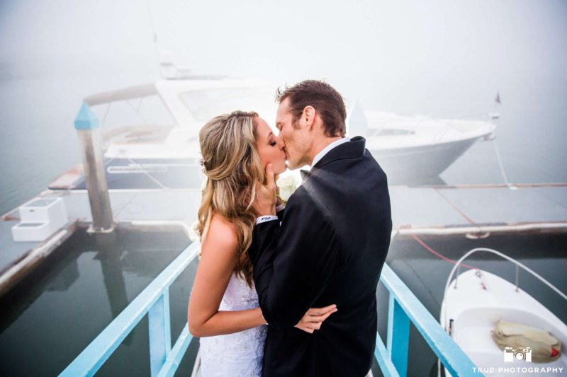Newlyweds on a dock in thick fog.