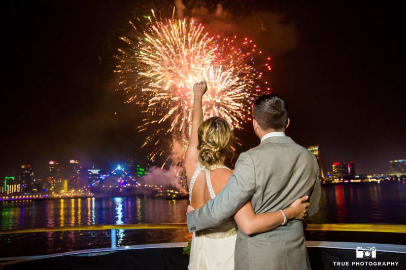 Bride and Groom embrace while watching fireworks in Downtown San Diego