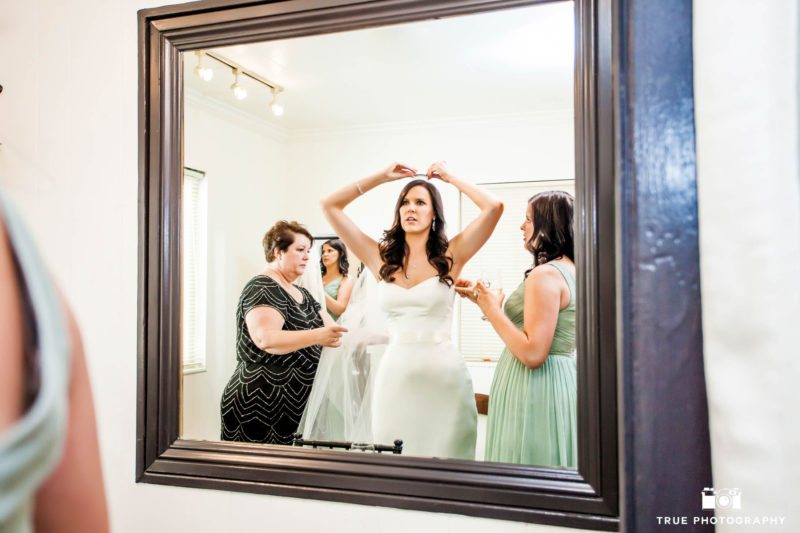 Bride looking in mirror and getting ready before ceremony