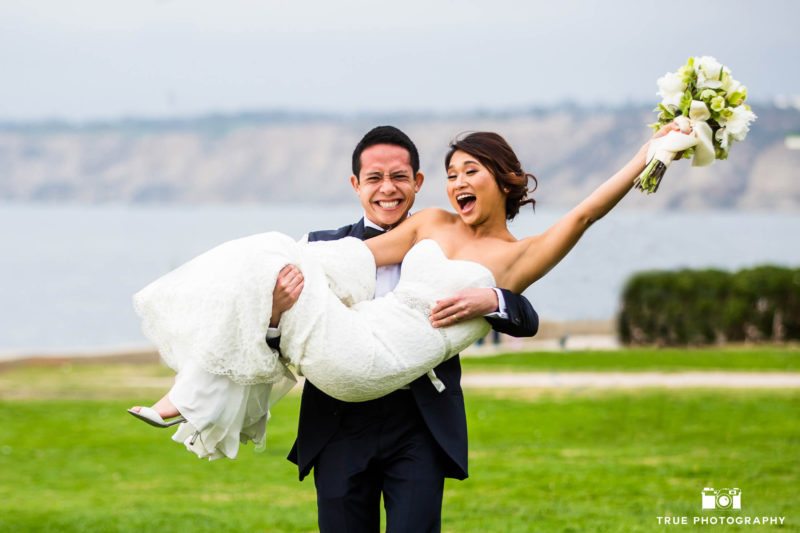 Groom carries Bride for funny photo at La Jolla Cove