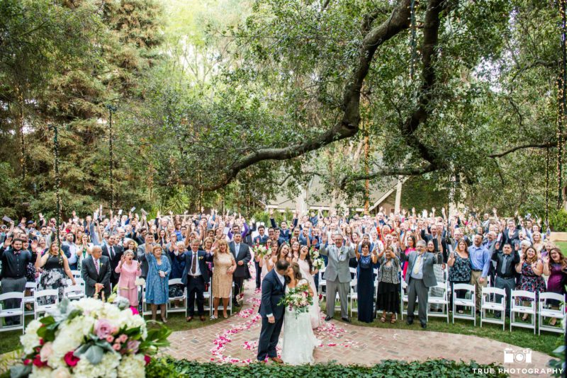 a couple takes a photo with everyone at their ceremony at once.