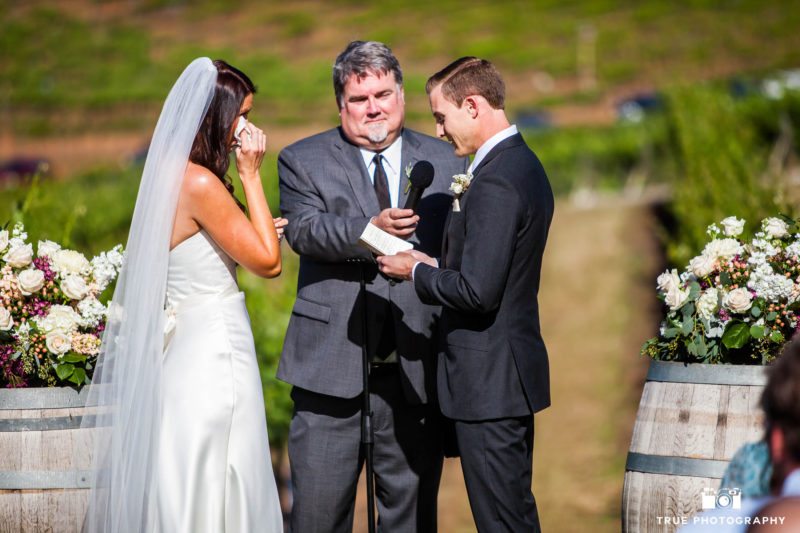 Bride crying while groom reads vows