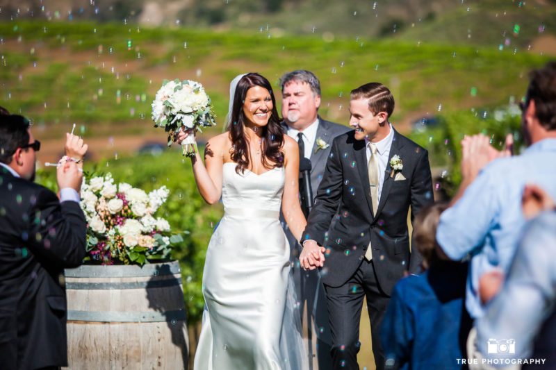Bride and Groom smile during bubble exit