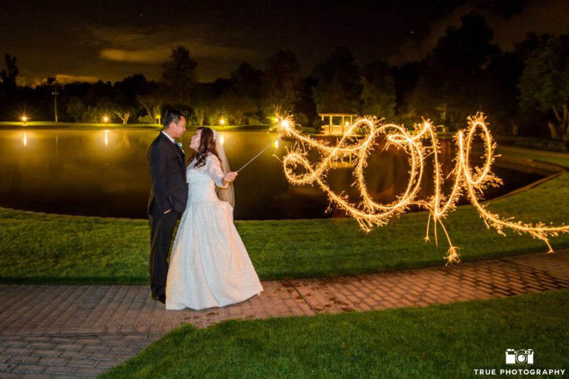 A couple writes love with a sparkler