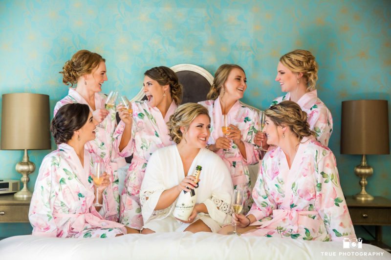 bride and bridesmaids getting ready with champagne