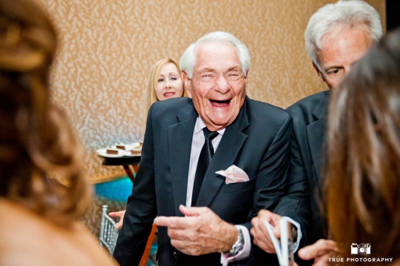 Old gentleman laughs candidly during wedding reception