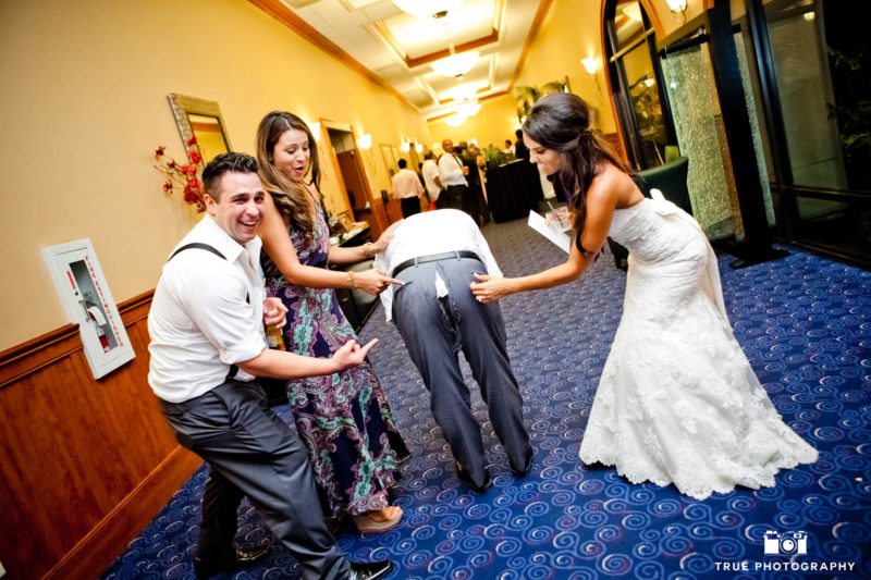 Bride and guests laugh at guests ripped pants