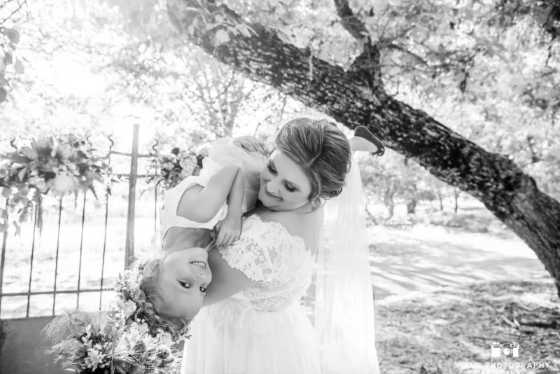 Funny photo of Bride with Flowergirl after rustic wedding ceremony