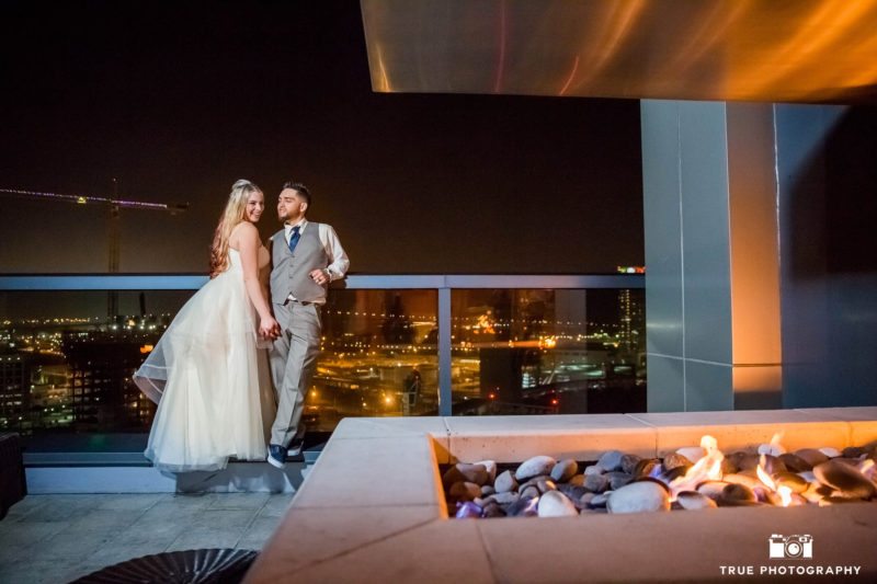 Night photo of bride and groom on balcony of Ultimate Skybox