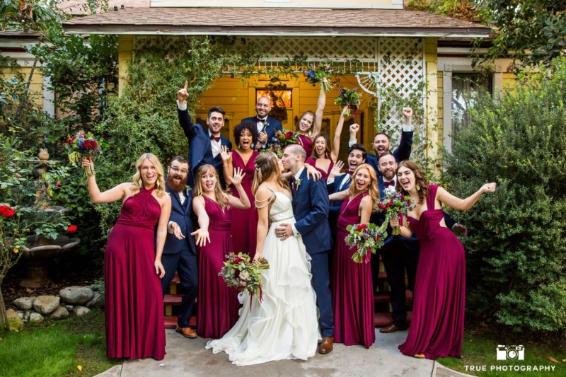 Bridal Party cheering while Wedding Couple Kiss