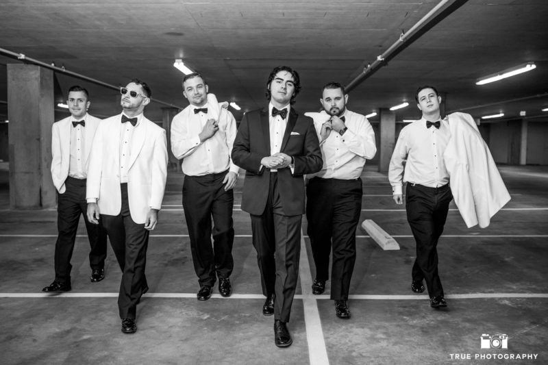 Stylish black and white portrait of groomsmen walking in garage at the Ultimate Skybox in Downtown