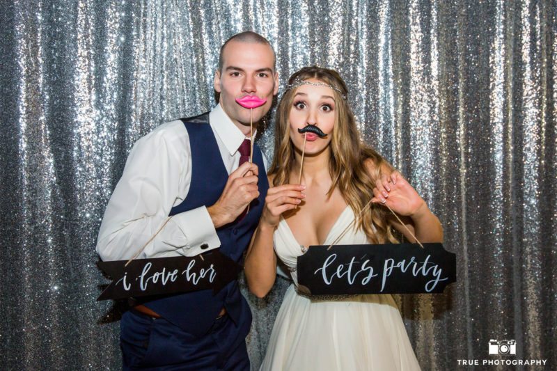 Bohemian bride and groom pose in Take-a-Pic photobooth during wedding reception