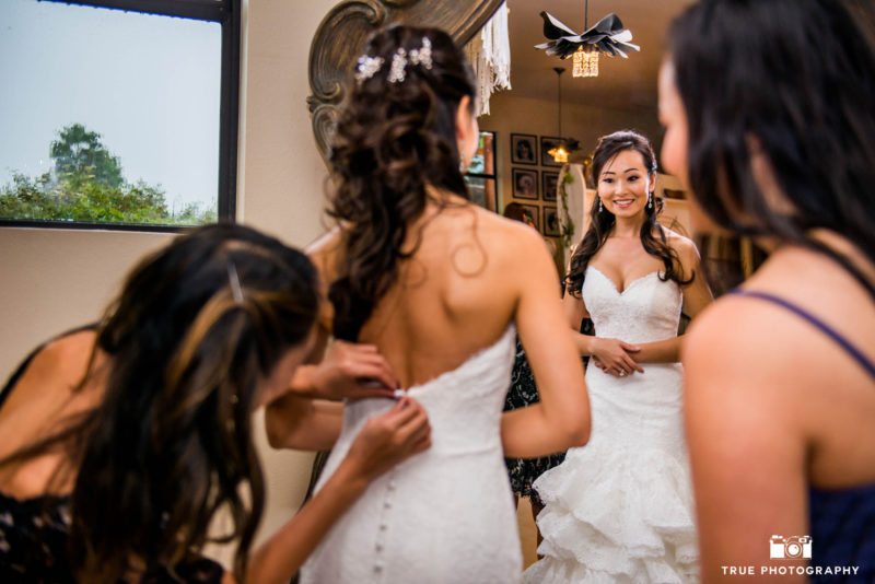 Bridesmaids helping bride get ready