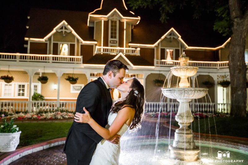Night photo of Bride and Groom kissing by Fountain