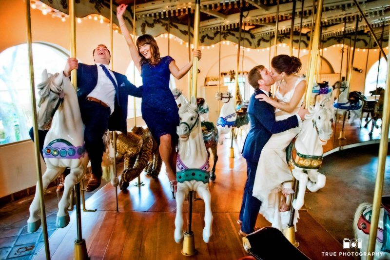 Bridal party have fun on carrousel
