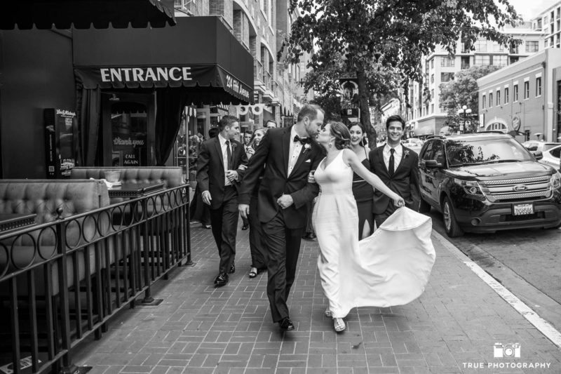 Newlyweds lead their bridal party downtown.