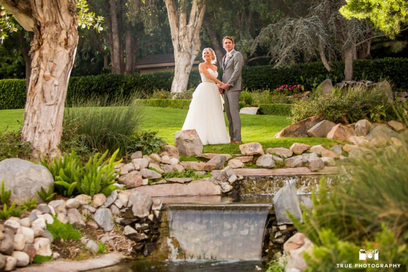 Bride and groom pose in the gardens of Grand Tradition Estate