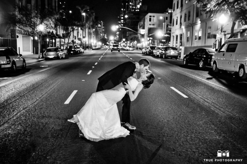 Bride and groom kiss at night
