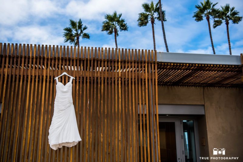 Wedding dress hanging from wood wall at Scripps Seaside Forum