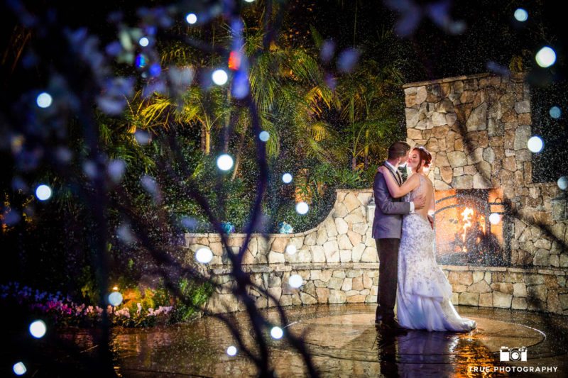 Bride and groom pose for a beautiful evening rain shot