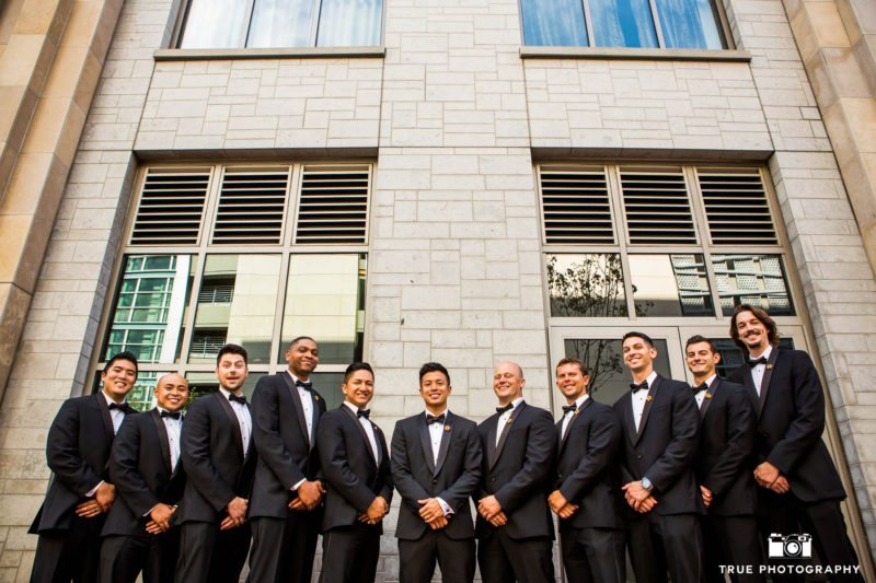 Groom with groomsmen in front of brick wall in downtown San Diego