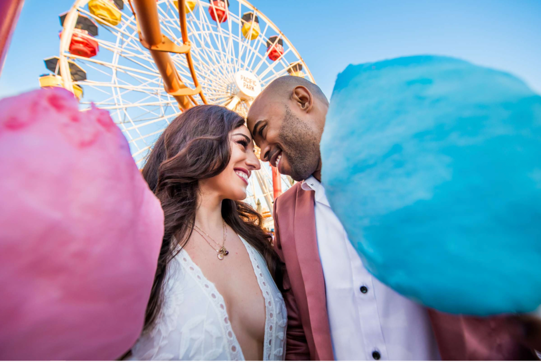 Professional San Diego wedding photographer captures couple at amusement park with cotton candy
