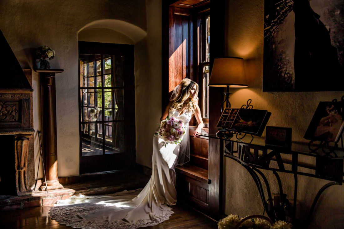 Bride dappled in window light at Mt Woodson Castle captured by True Photography
