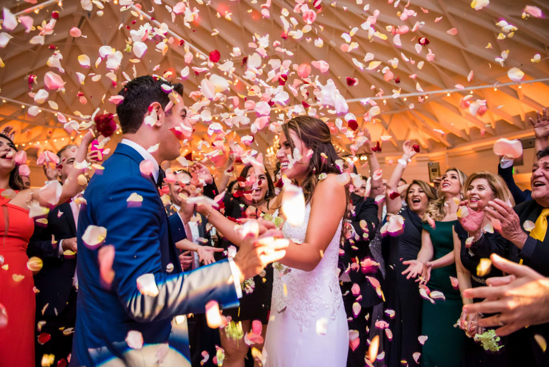 Bride and Groom at their wedding receptions adorned in rose petals captured by True Photography